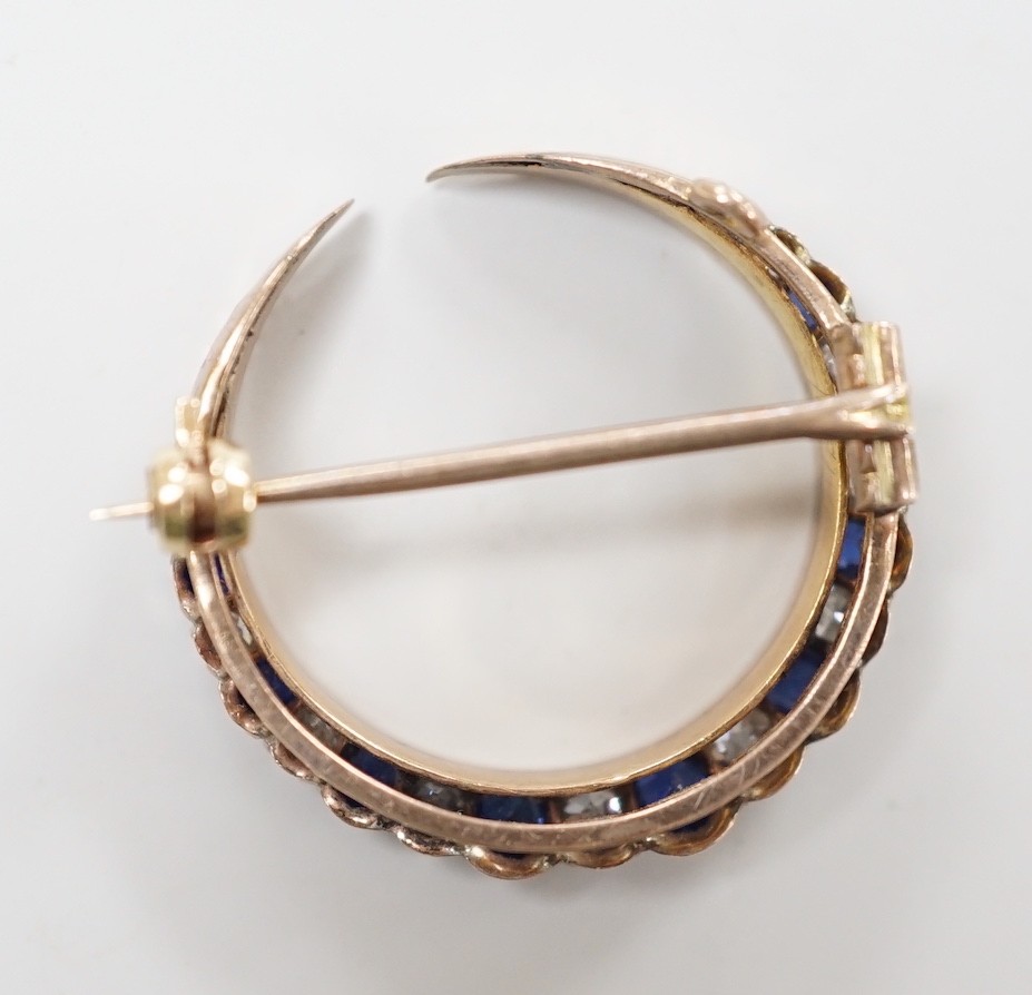 An Edwardian yellow metal, graduated sapphire and diamond set crescent brooch, 22mm, gross weight 3 grams.